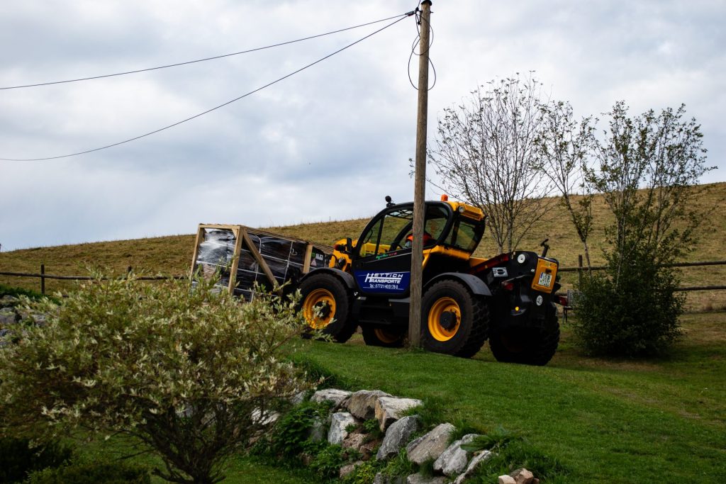 Traktor mit Holztransport auf Wiese